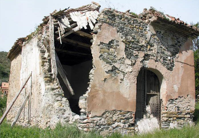 Fachada principal de la Iglesia. Apoyado en la puerta, bloque  de artesonado desprendido del techo.