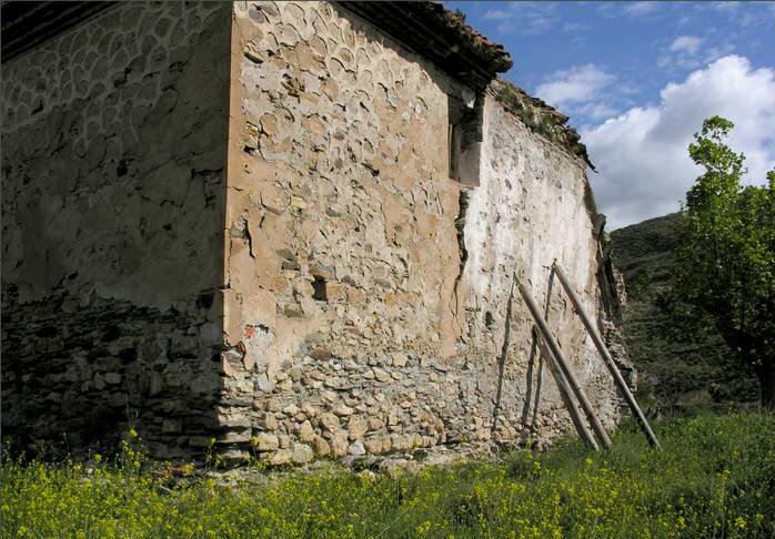 Muro semiderruido, apuntalado con vigas de madera