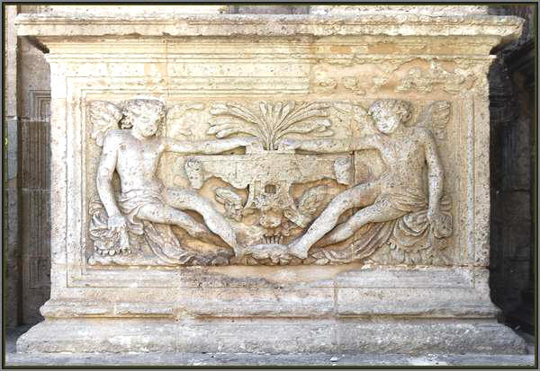Plinto que sustenta las columnas del primer cuerpo, con figuras aladas sedentes.