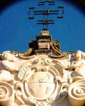 Escudo del Hospital de las Cinco Llagas. Los cinco racimos de uva simbolizan la sangre de Cristo presentes en la Eucarista.