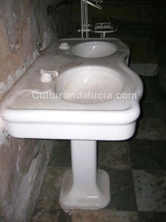 Botiquín. Lavamanos de porcelana con dos senos y grifos de agua.