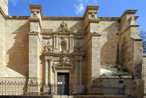 Protegido por lonja de hierro forjado, el retablo de la Puerta de los Perdones se sitúa entre dos sólidos contrafuertes.