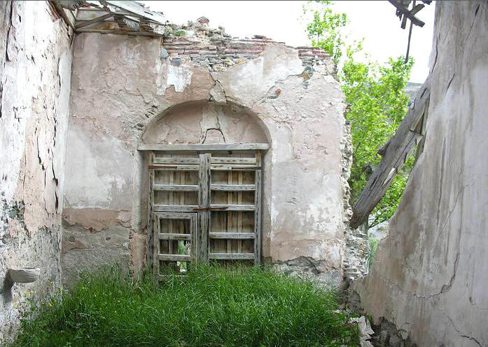 Puerta de acceso desde el interior de la iglesia. A la izquierda, pila de agua bendita