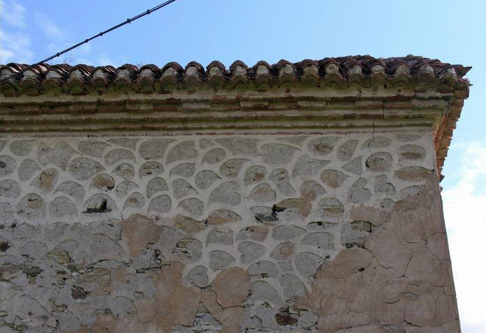 Decoraci�n esgrafiada en el muro y voladizos de tejas y ladrillos de  la cubierta.